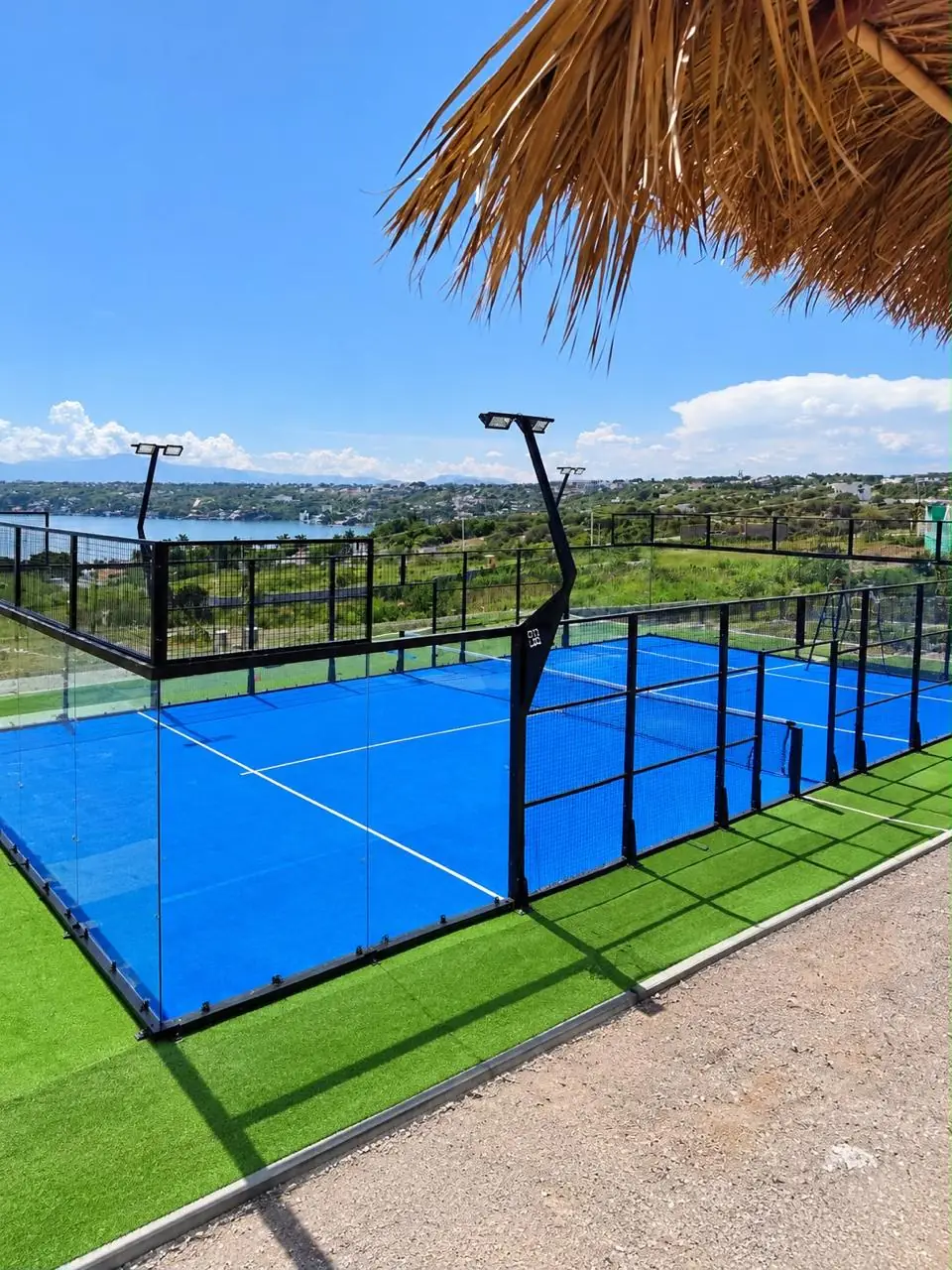 Cancha de pádel panorámica azul con vista a un lago, vista desde una palapa, en Morelos