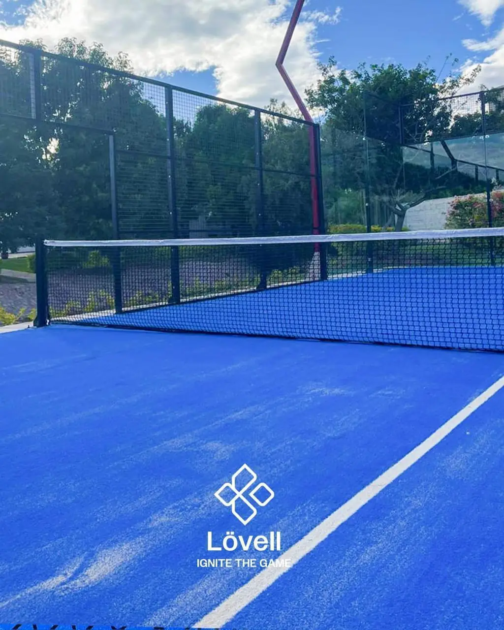 Red y poste de luz en V rojo de una cancha de pádel residencial en San Luis Potosí