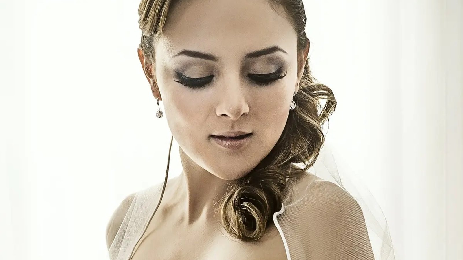 Maquillista profesional trabajando con novia en estudio especializado