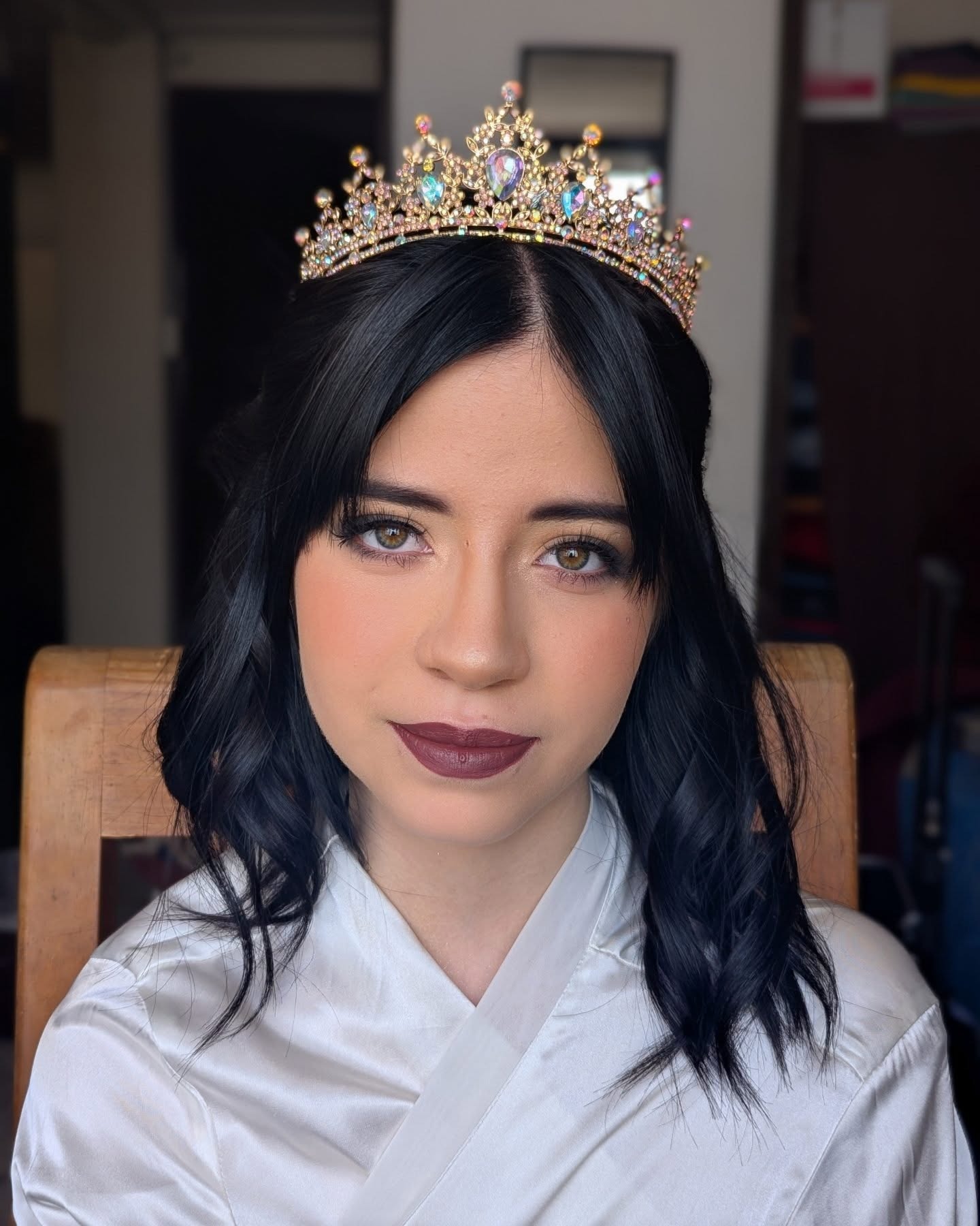 Quinceañera con tiara lista para su fiesta, con look Soft Glam de ojos difuminados y labio berry hecho por Marlene Rivera.